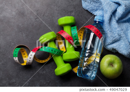 Fitness concept. Dumbbells, tape measure and apple 49047029