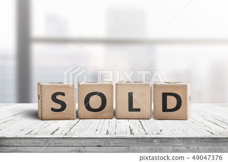 Sold sign on a wooden table Sold sign on a wooden table 49047376