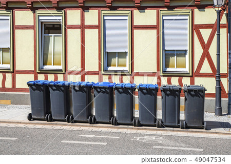 Garbage bins on the street outside an old house 49047534
