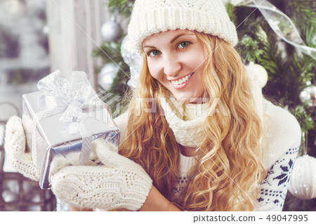 Happy young woman with Christmas present in her 49047995