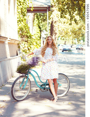 Beautiful and happy young woman with bicycle 49047996