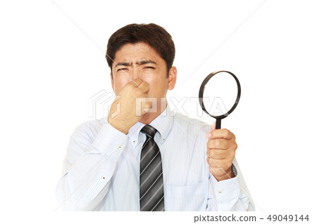 A man picking his nose 49049144