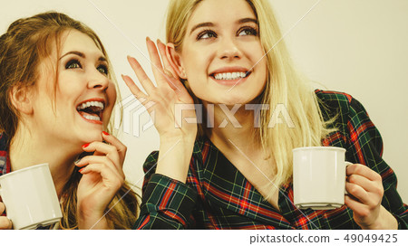 Female friends gossiping together 49049425