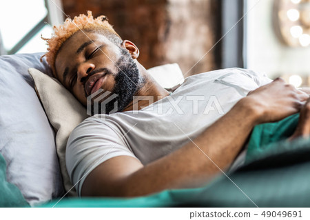 Handsome African American man lying on his bed 49049691