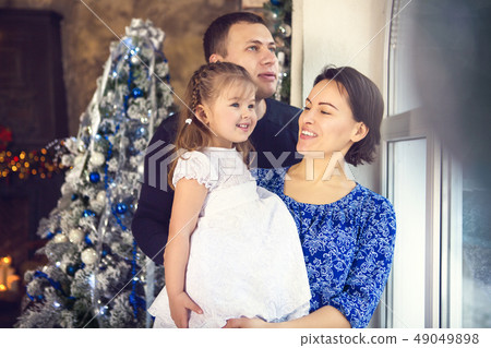 Happy family with little daughter by the Christmas 49049898