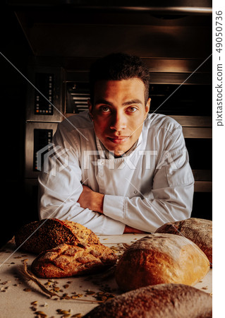 Serious professional baker standing near table after making bread 49050736