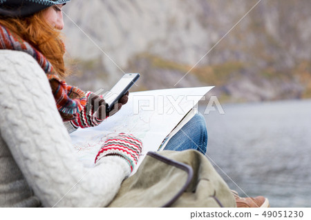 Woman traveler with a backpack, map and phone Woman traveler with a backpack, map and phone 49051230
