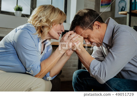 Desperate old man leaning on hand of his wife 49051729
