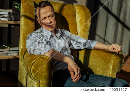 Good-looking short-haired man resting in a spacious armchair 49051827