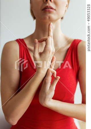Meditative young girl in slinky red costume connective hands in unusual way Meditative young girl in slinky red costume connective hands in unusual way 49053328