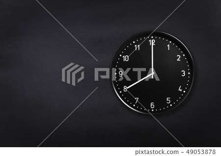 Wall clock showing eight o'clock on black chalkboard background. Office clock showing 8am or 8pm on Wall clock showing eight o'clock on black chalkboard background. Office clock showing 8am or 8pm on 49053878