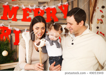 Family with one year daughter near the Christmas Family with one year daughter near the Christmas 49053949