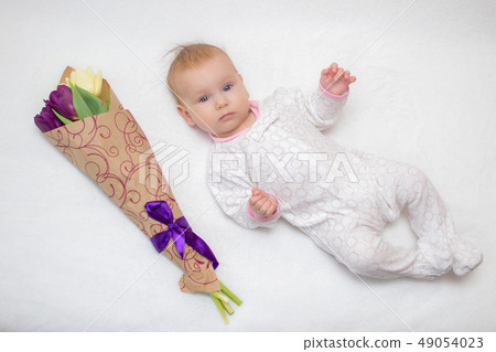 baby lies on a plaid next to a bouquet of tulips baby lies on a plaid next to a bouquet of tulips 49054023