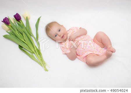 baby lies on a plaid next to a bouquet of tulips baby lies on a plaid next to a bouquet of tulips 49054024
