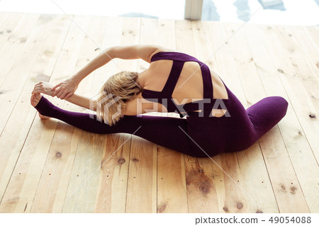 Talented well-trained woman leaning on wall with both legs 49054088
