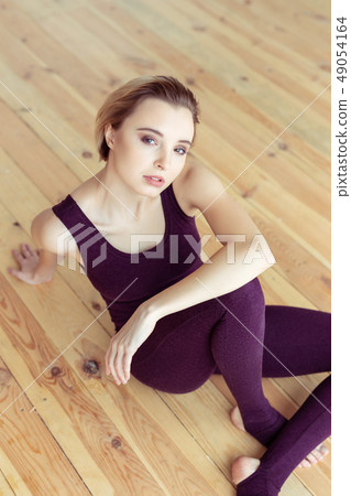 Blonde short-haired woman sitting in closed posture and showing her emotions 49054164