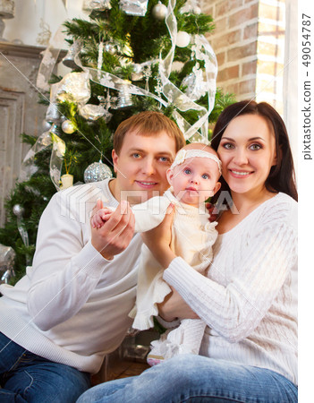 Happy family with Christmas baby near the Happy family with Christmas baby near the 49054787