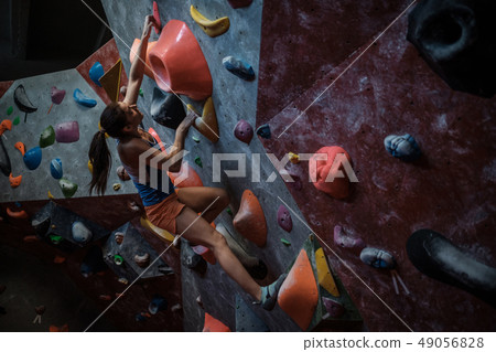 Athletic woman practicing in a bouldering gym 49056828