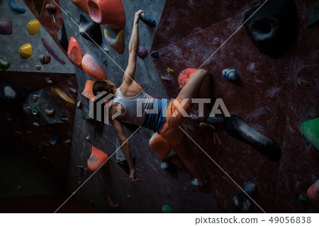 Athletic woman practicing in a bouldering gym 49056838