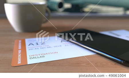 Boarding pass to Dallas and smartphone on the table in airport while travelling to the United States 49061004