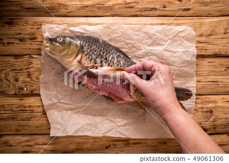 Cook removes carp skin 49061306