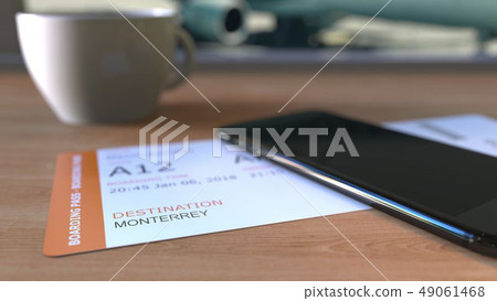 Boarding pass to Monterrey and smartphone on the table in airport while travelling to Mexico. 3D 49061468