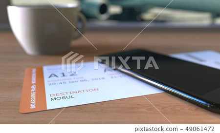 Boarding pass to Mosul and smartphone on the table in airport while travelling to Iraq. 3D rendering 49061472