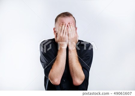 Portrait of man in black shirt closes his eyes with hands 49061607