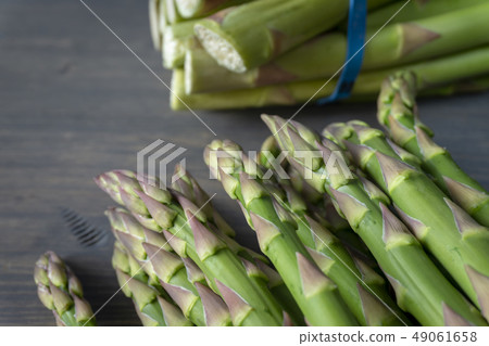 Fresh green asparagus on wooden background Fresh green asparagus on wooden background 49061658