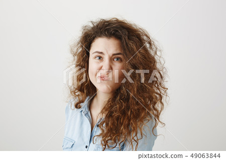 Portrait beautiful woman face close up portrait young curly hair studio on gray Portrait beautiful woman face close up portrait young curly hair studio on gray 49063844