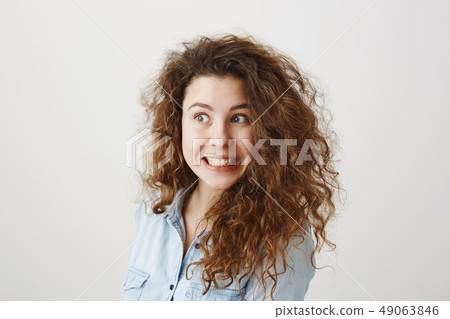 Portrait beautiful woman face close up portrait young curly hair studio on gray 49063846
