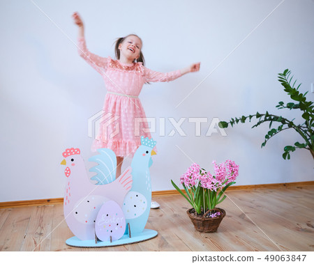 Easter 2019 Beautiful little girl in a dress with Easter decorations. Big Easter eggs and bunnies 49063847