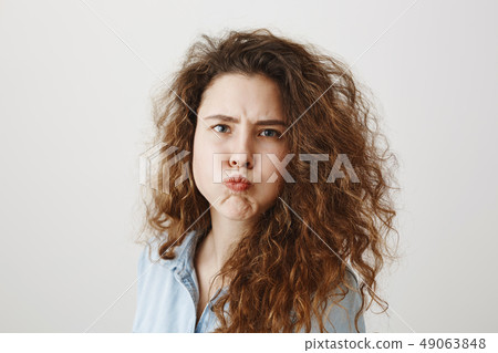 Portrait beautiful woman face close up portrait young curly hair studio on gray Portrait beautiful woman face close up portrait young curly hair studio on gray 49063848