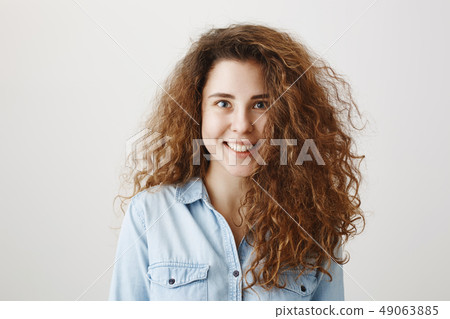 Portrait beautiful woman face close up portrait young curly hair studio on gray Portrait beautiful woman face close up portrait young curly hair studio on gray 49063885