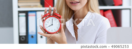 Smiling business woman holding in hand clock Smiling business woman holding in hand clock 49065253