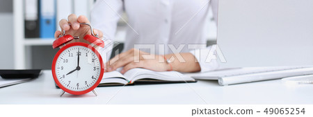 Smiling business woman holding in hand clock Smiling business woman holding in hand clock 49065254