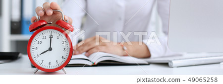 Smiling business woman holding in hand clock Smiling business woman holding in hand clock 49065258