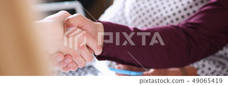 Man in suit shake hand as hello in office Man in suit shake hand as hello in office 49065419