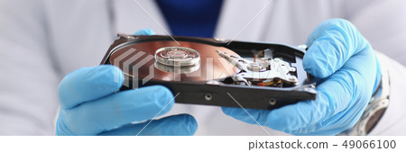 male repairman wearing blue gloves is holding a hard drive male repairman wearing blue gloves is holding a hard drive 49066100