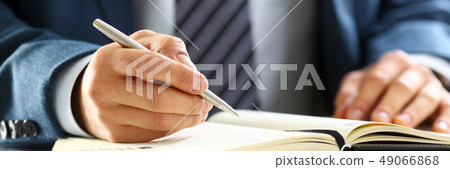 Male arm in suit and tie hold silver pen 49066868