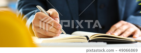 Male arm in suit and tie hold silver pen 49066869