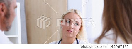 Female family doctor listen carefully young couple Female family doctor listen carefully young couple 49067585