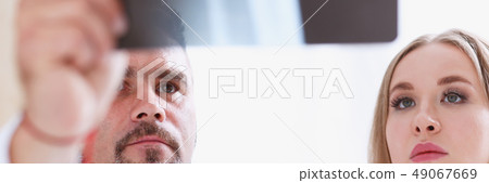 Mature male doctor hold in arm and look at xray photography 49067669