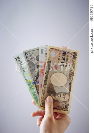 拿著一萬日元票據和海外鈔票的女性手 49069753