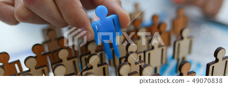 businessman in blue shirt is holding a magnifying glass in his h 49070838