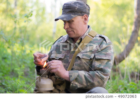 hunter in camouflage splashes the kerassene lamp 49072063