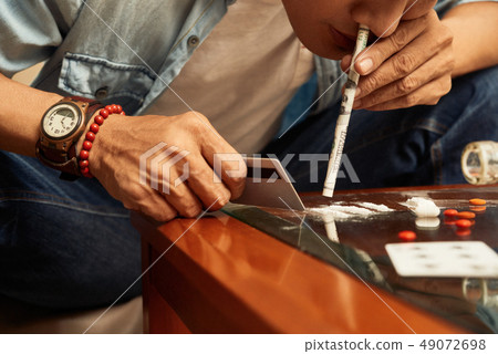 Man making lines of cocaine 49072698