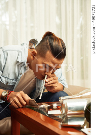 Young man snorting cocaine 49072722