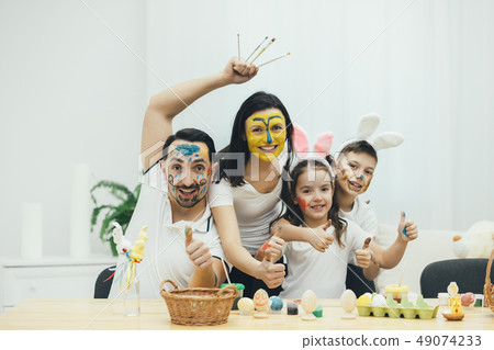 Creative family, children in bunny ears. Everyone with colored faces. They are extremely happy and 49074233