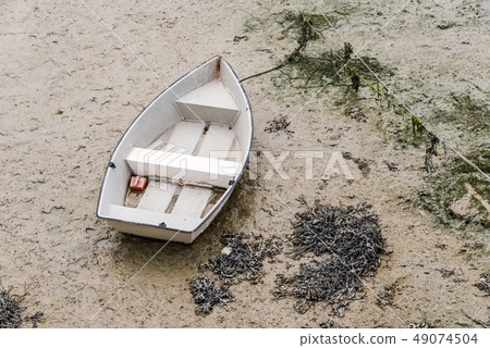 Boat stranded at low tide in the port of Cancale 49074504